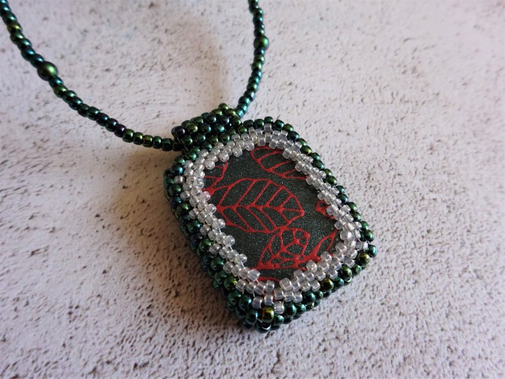 Polymer clay focal bead with beaded bezel