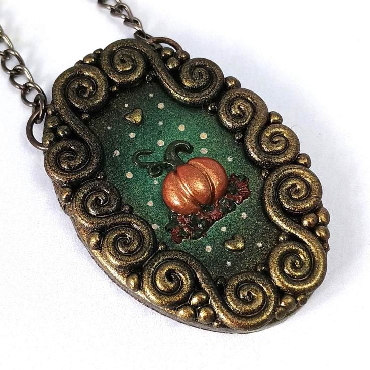 A close up of a pumpkin mini art made from polymer clay