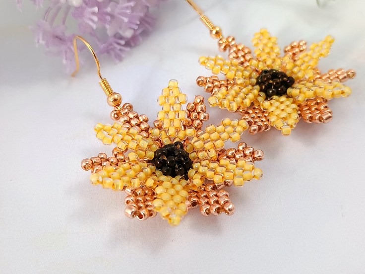 Seed bead sunflower earring on a white background.