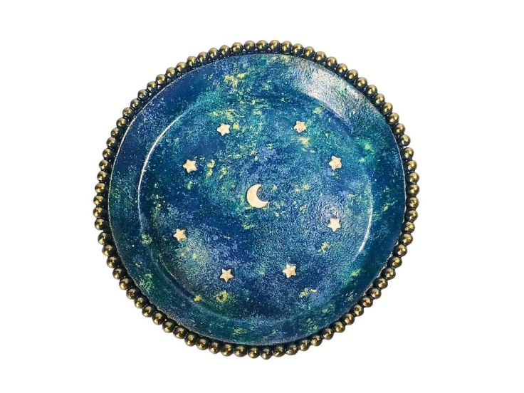 An aerial view of a polymer clay ring dish with a moon and stars design