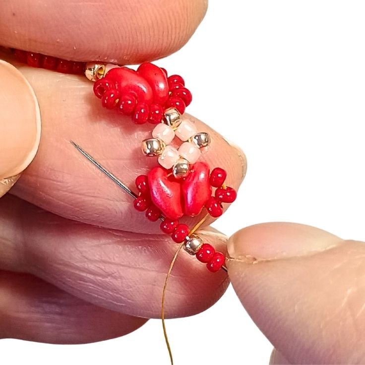 A red seed bead and super duo bracelet being beaded.