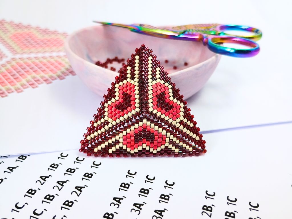 A heart themed peyote bead pattern sitting against its pdf pattern