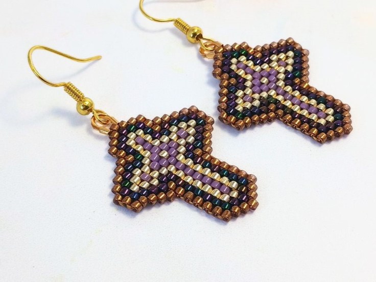 Close up of a pair of peyote stitch cross earrings