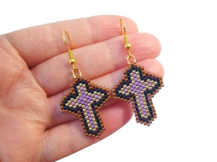 Peyote stitch cross earrings being held