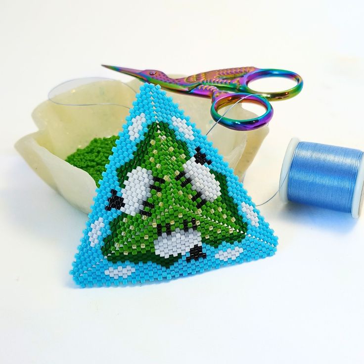 Sheep in a field peyote triangle set against a bowl of beads.