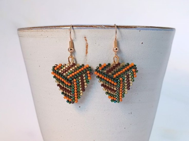 A close up of a pair of peyote triangle earrings